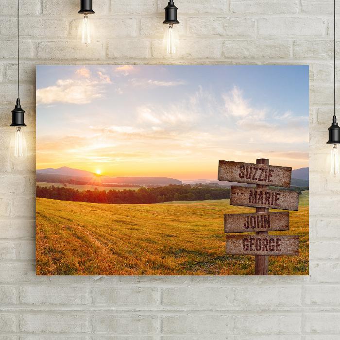 Sunset or sunrise over distant mountains is the backdrop for this personalized landscape field photo with custom personalized wood plank crossroads signs.